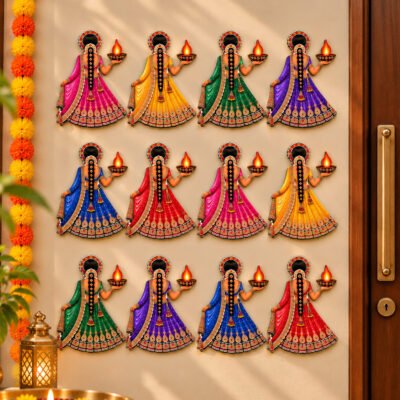 Set of twelve vibrant Indian lady wall cutouts dressed in colorful lehengas while holding glowing diya lamps beside a main door.