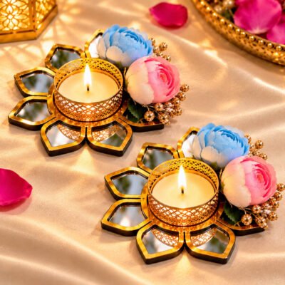 Gold floral mirror tealight candle holders with blue and pink artificial flowers on a silk backdrop.
