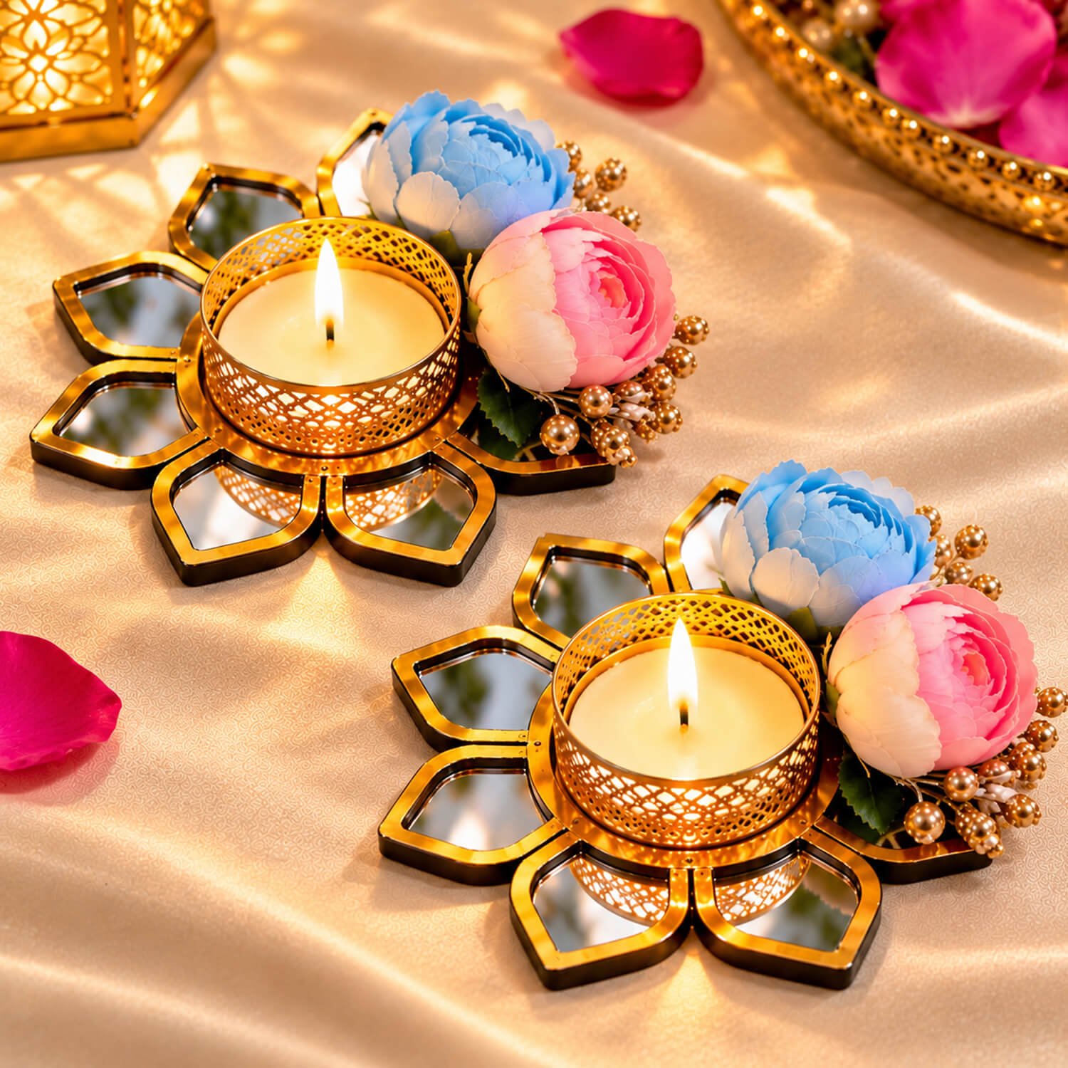 Gold floral mirror tealight candle holders with blue and pink artificial flowers on a silk backdrop.